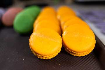 macaroons shells in a tray fresh from oven. Process of making macaron macaroon , french dessert. Food industry,