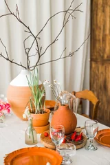 Fotobehang Eetkamer still life with vegetables and flowers. A close up shot of a restaurant table set up with tableware and wine glass. Concept of dining, hospitality and catering.  © Lena
