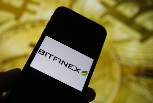Viersen, Germany - February 9. 2021: Closeup of mobile phone screen with logo lettering of bitstamp trading platform, blurred bitcoins background