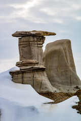 Winter clings to the hoodoos as spring arrives in the badlands. Drumheller Alberta, Canada.