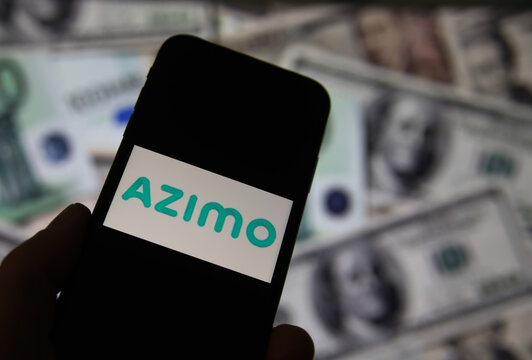 Viersen, Germany - February 9. 2020: Closeup of smartphone screen with logo lettering of online money transfer service azimo, blurred banknotes background