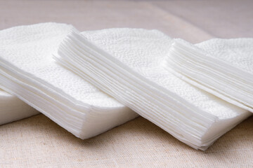 Paper napkins white decomposed into several small piles and lie on each other. They are used for hygienic purposes for hands and face, as well as for eating. Tableware for restaurants and cafes.