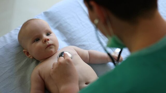 newborn baby get examine by pediatrician hold stethoscope, pediatric doctor monitoring heart pulse rate adorable infant  in clinic, pediatrician with child concept