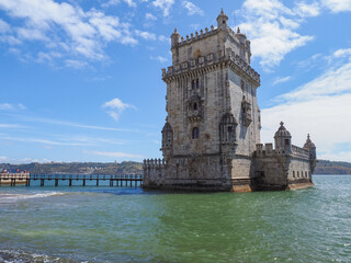 Fototapeta premium Beautiful landscape. Belém Tower or Torre de Belém. Ancient, historic fortified quarter of Portuguese Manueline style on the northern bank of the Tagus river in Lisbon. Capital of Portugal.