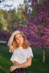 beautiful teenage girl near blooming pink spring tree. Romance, harmony, relaxation. Hi spring. Digital detox, enjoy the beauty of nature.