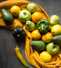Fresh vegetables and fruits on a table. Organic pepper, apples, oranges, squashes, tomatoes, avocado, pears and lemons top view photo.  Seasonal vegetables and fruits top view. 