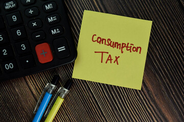 Consumption Tax write on sticky notes isolated on Wooden Table. Business of Finacial concept
