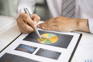 The chief finance officer is reviewing the company's financial chart documents before meeting with...