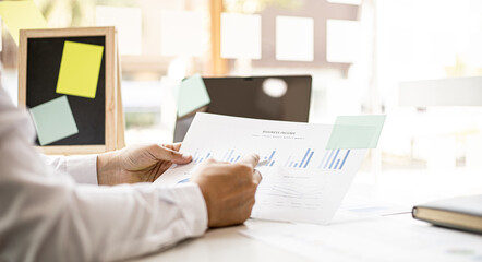 The chief finance officer is reviewing the company's financial chart documents before meeting with the management for presentation, he checks the accuracy of the documents produced by the finance team