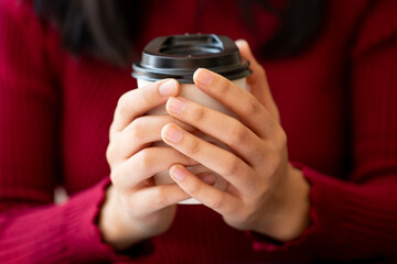 Fototapeta premium Closeup of female hands with Hot drink in paper cup.