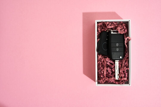 Luxurious Gift To Your Beloved Woman. Top View Of A Car Key In Gift Box On Pastel Pink Background