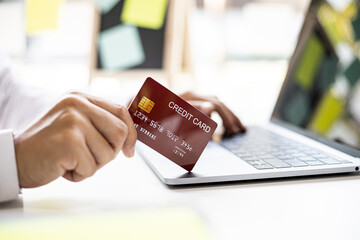 Men hold red credit cards to pay for items purchased through online shopping sites, online shopping is an option that does not leave home, but can shop. Credit card concept.