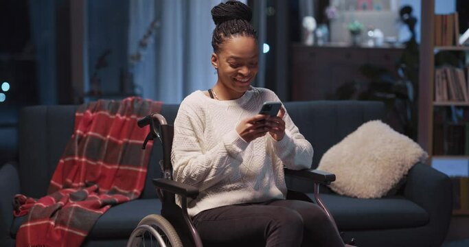 Attractive african girl in wheelchair using mobile phone receiving positive message smiling communicating online staying home.