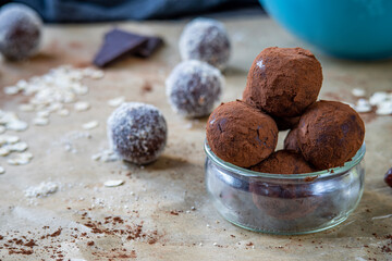 Healthy energy protein balls with dates, oats, peanut butter and dark chocolate. Homemade gluten free truffle bites covered with cocoa powder. Vegan and vegetarian raw appetizer or food snack.