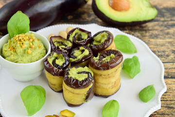Eggplant rolls. Aubergine rolled with avocado basil sauce and pistachios