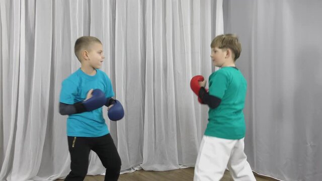 Two athletes in multi-colored T-shirts and pads on their arms practice pair exercises