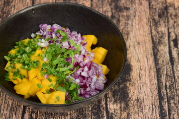 making mango salsa in a bowl 
