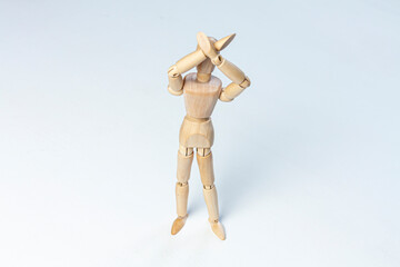 a wooden mannequin crossing his hands above his head and forbidding something on white background