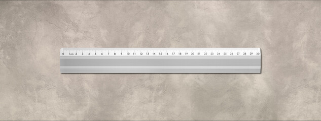 Metal ruler isolated on concrete background