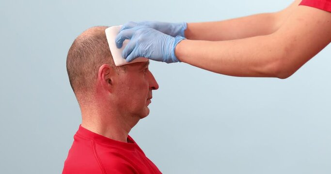 A medical instructor teaches how to bandage the head in case of an injury. Demonstration CPR first aid.