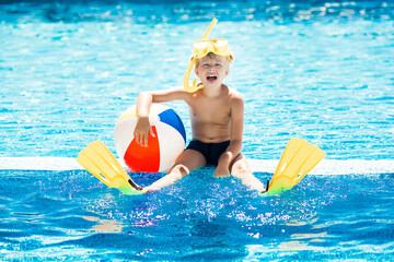Cute little child in swimming pool. Funny kid swimming.