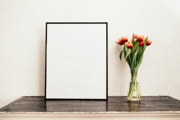 Blank frame and tulips in a vase