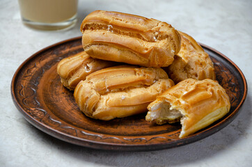 eclairs on a brown clay plate, close-up