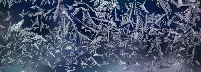 Frosty patterns on the window. Ice crystals on a winter window in high resolution, close-up