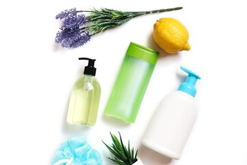Eco friendly bath products top view photography. Liquid soap, green shampoo bottle, hair balm, lemon, lavender flowers and leaves