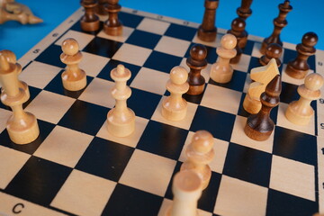 Close-up of chess on a blue background. Wooden chess pieces. Concept: the Board game and the intellectual activities