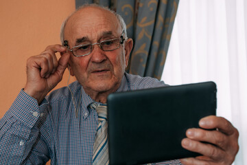 senior with digital tablet at home