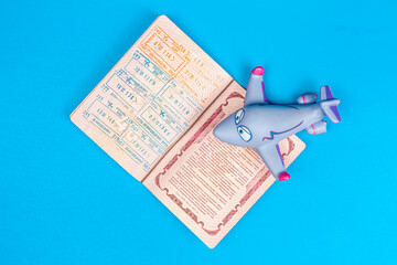 a foreign passport and toy plane on blue background