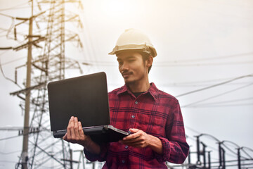 Engineer hold laptop computer inspection on site power plant high volte system