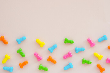 multi-colored sweets in the form of penises on a light background. copy space..