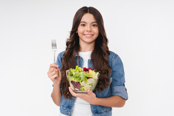 Cheerful teenage girl eating salad isolated in white background
