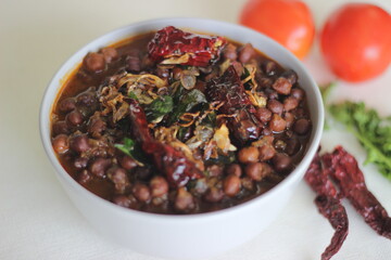 Black chickpeas curry prepared by chickpeas cooked with onions, tomatoes and spices.