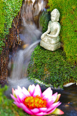 Buddha sculpture sitting in flowing water