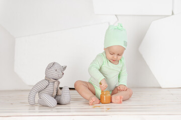 baby feeding spoon toy in green bodysuit, feeding and baby food concept