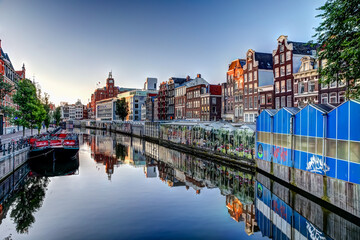 Reflections of iconic buildings along an Amsterdam canal