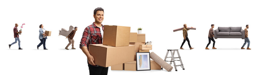 Smiling man carrying boxes and other people moving household items