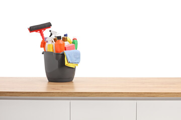 Bucket full of cleaning supplies on a wooden counter
