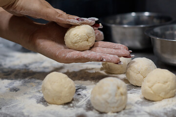 woman chef preparing dough makes the cheesecakes in the kitchen close up blurred background
