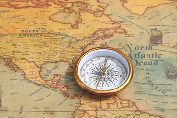 Naklejka na ściany i meble Classic round compass on background of old vintage map of world as symbol of tourism with compass, travel with compass and outdoor activities with compass