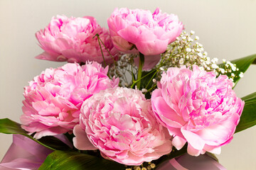 Beautiful bouquet of pink peonies on a gray background.