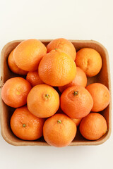 Fresh tangerines on biodegradable pulp paper food tray isolated on white. Recyclable packaging concept.  Top view, copy space, stock photo