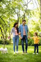 Happy family with cute bichon dog in the park