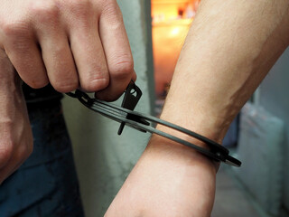 a man's hand with a key opens the handcuffs