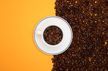 Naklejka premium Top view of coffee cup with many coffee beans on the one side and on the other side yellow background for copy space