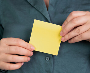 Business woman holding a blank yellow memo notepaper, sticky note for copy space, space for text, business,communication,education,design concept