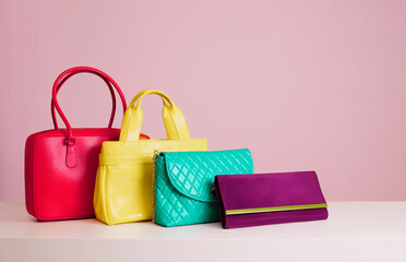 Colourful woman bags on pink background 